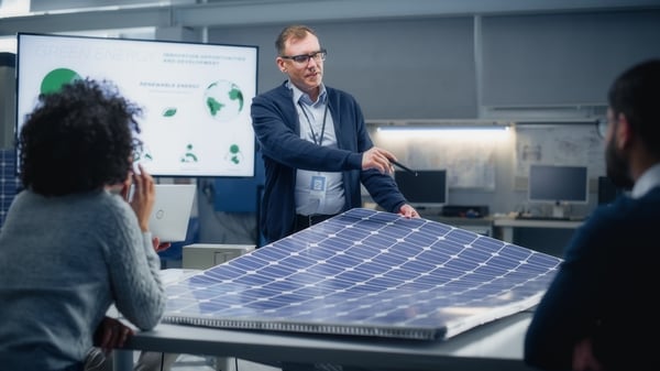 Mann viser innovasjon og solcellers til kolleger