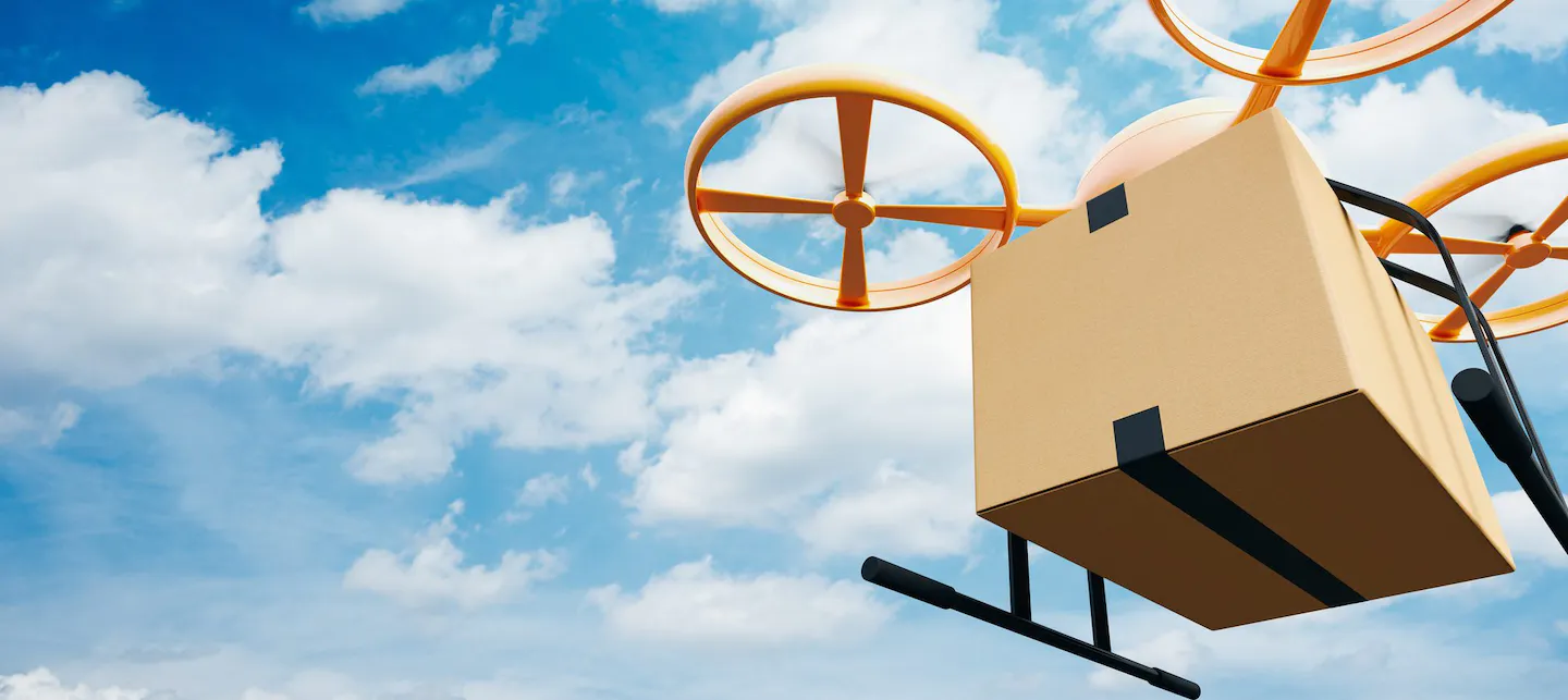 En flyvende pappeske utstyrt med droneteknologi med en blå himmel i bakgrunn.