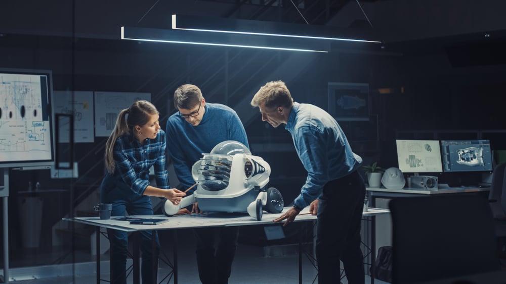 Tre personer som studerer en ny robot
